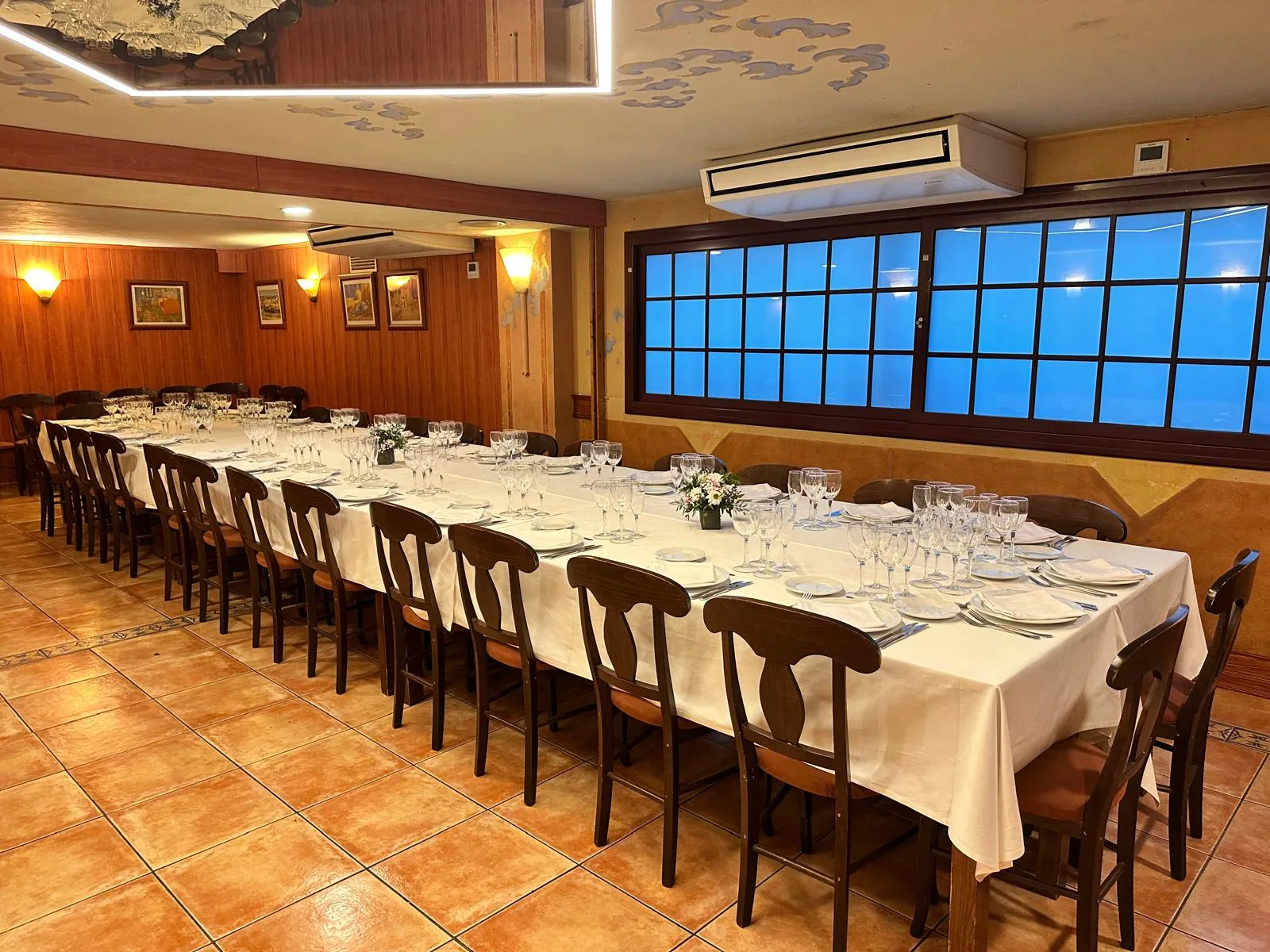 Salón con una larga mesa preparada para un banquete